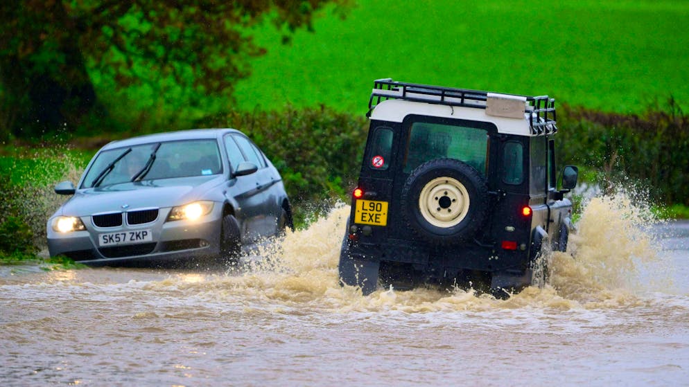 Several dead in storms in Great Britain - Gallery. Cars drive on flooded roads in Devon, Exeter.