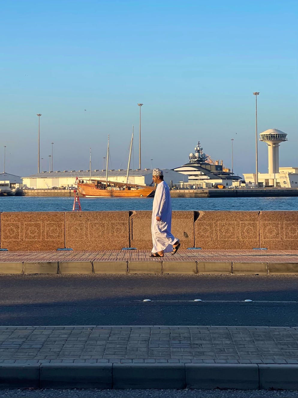 Reisebericht Oman. Ein Mann geht am Hafen entlang. 