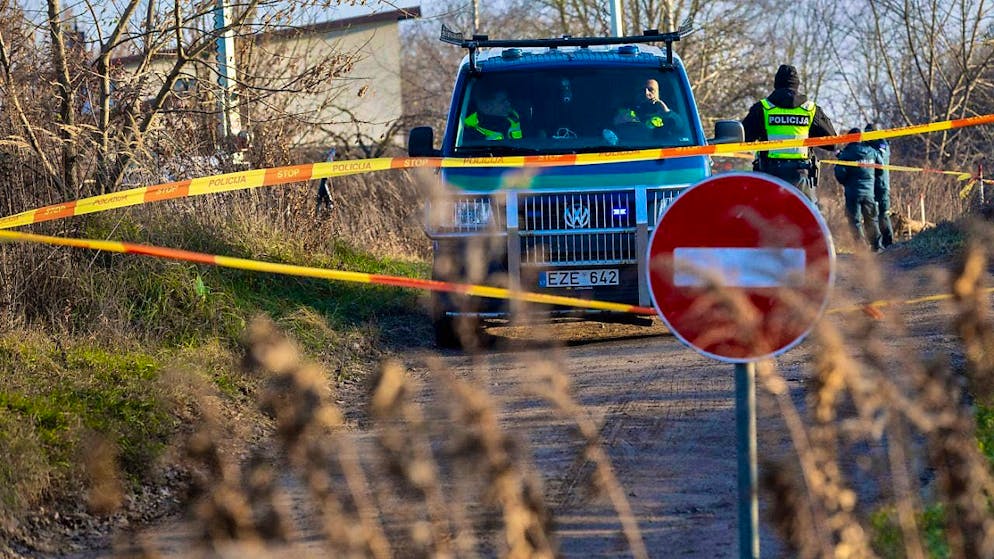 Lithuanian police close the road while investigators work at the crash site. Photo: Mindaugas Kulbis/AP