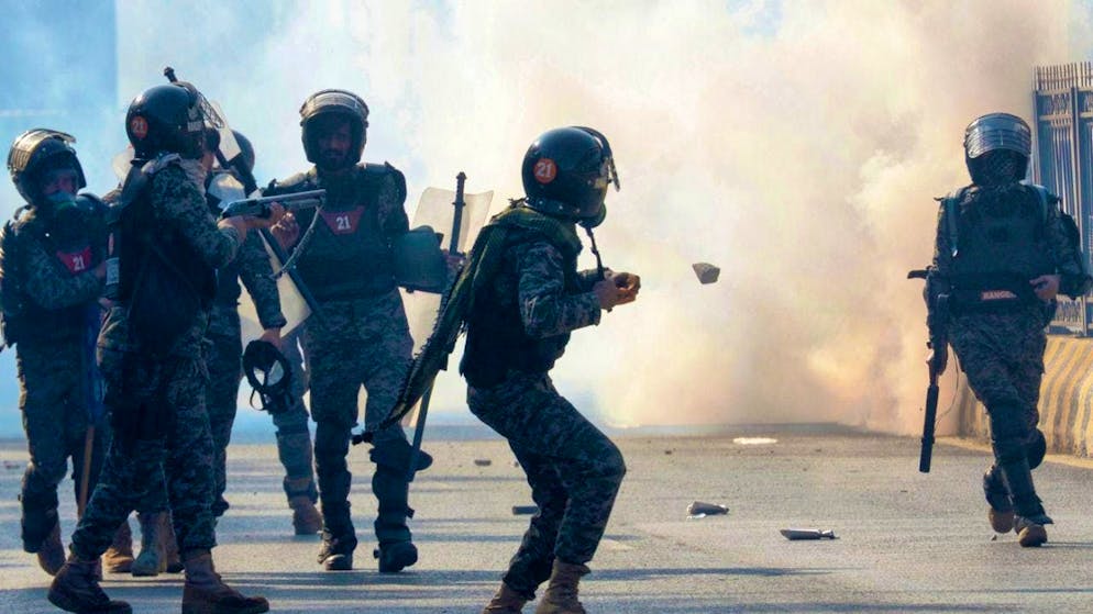 Paramilitary soldiers fire tear gas grenades. Photo: Irtisham Ahmed/AP/dpa
