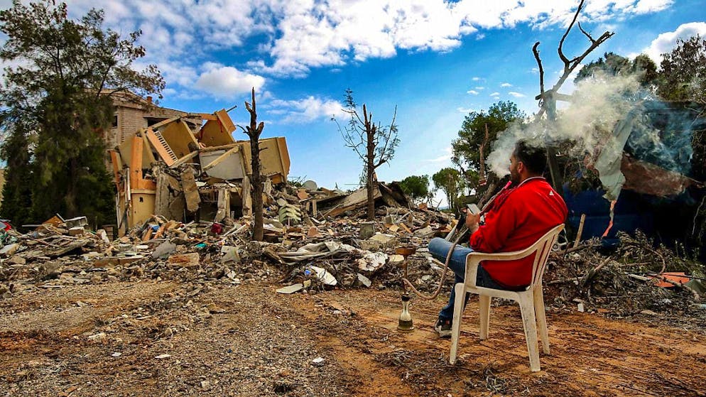 dpatopbilder - Taymor Jaber, a resident of the southern city of Nabatieh, smokes his shisha while sitting in front of his destroyed home. Photo: Marwan Naamani/dpa