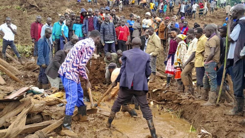 Soccorritori e persone alla ricerca dei corpi dei dispersi dopo che alcune frane, causate dalle piogge, hanno investito diversi villaggi dell'Uganda orientale