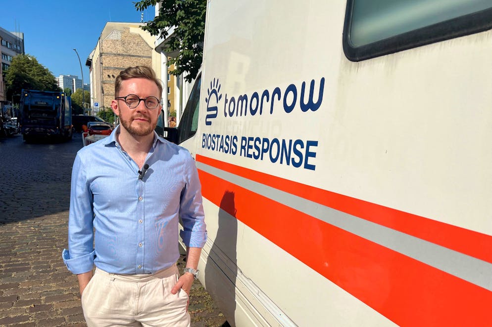 Emil Kendziorra, PDG de Tomorrow Biostastis, pose à côté de l'une des ambulances de l'entreprise devant son siège à Berlin, le 4 septembre 2024. - Autrefois réservé aux milliardaires excentriques, le domaine de la congélation cryogénique - également connu sous le nom de cryogénie - est devenu plus accessible ces dernières années. (Photo par Raphaelle LOGEROT / AFP)