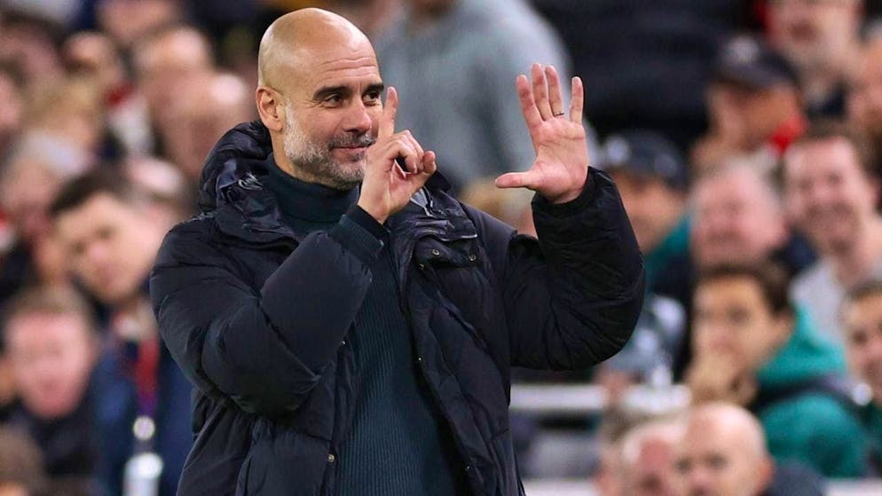 Pep Guardiola reacts to the chants of abuse from the crowd by sticking his fingers up six times
