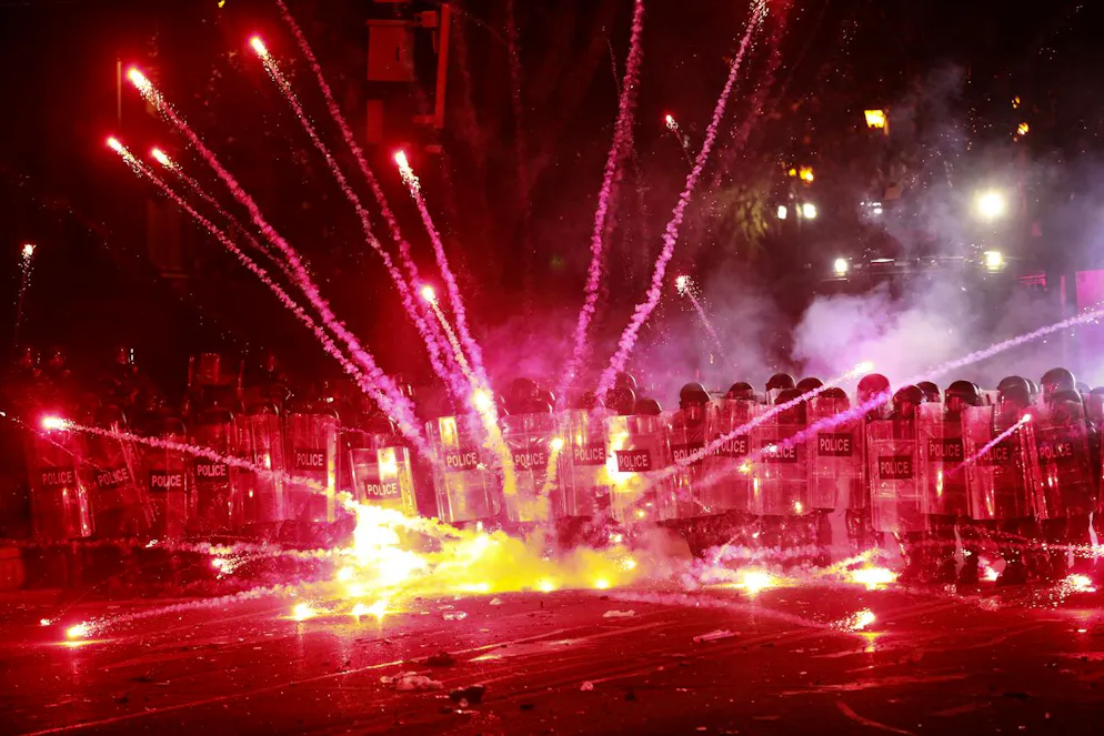  Dimostranti usano petardi contro la polizia durante una manifestazione contro la decisione del governo di sospendere per quattro anni i negoziati per l'adesione all'Unione Europea, fuori dall'edificio del Parlamento a Tbilisi, in Georgia, all'inizio di domenica 1 dicembre 2024.