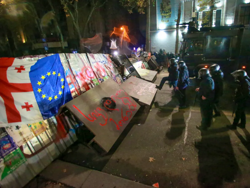 Polizisten neben einer Barrikade, die von Demonstranten während einer Kundgebung vor dem Parlamentsgebäude in Tiflis errichtet wurde.