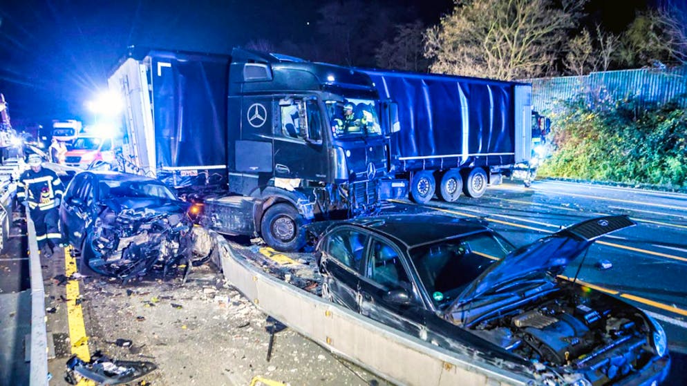 Der Lastwagen auf der Autobahn 1 bei Hagen an der Unfallstelle neben beschädigten Autos. Foto: Alex Talash/dpa