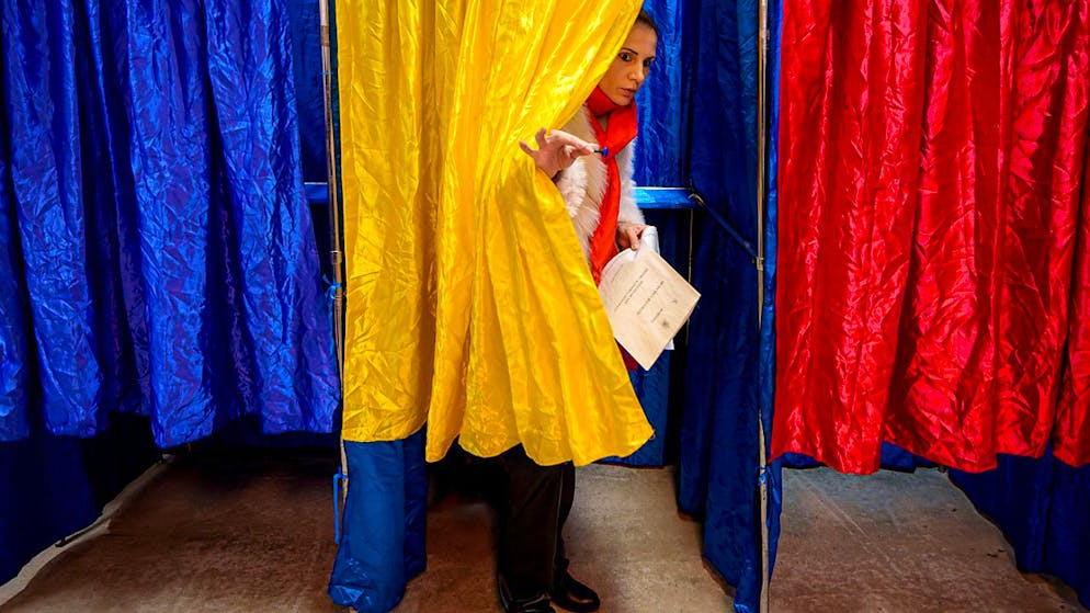 dpatopbilder - Eine Frau verlässt in Bukarest eine Wahlkabine. Foto: Andreea Alexandru/AP/dpa