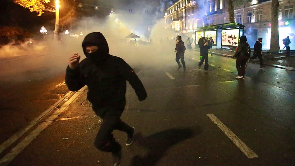 Demonstranten fliehen vor einer Tränengaswolke während einer Kundgebung gegen die Entscheidung der Regierung, die Verhandlungen über den Beitritt zur Europäischen Union für vier Jahre auszusetzen, in Tiflis, Georgien. Foto: Zurab Tsertsvadze/AP/dpa