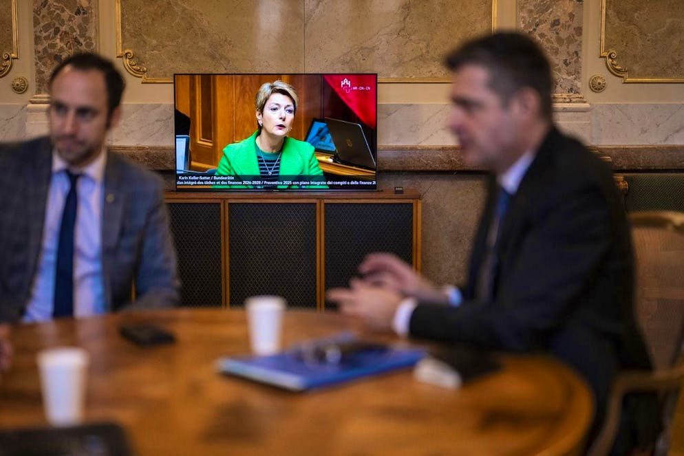 Finance Minister Karin Keller-Sutter's speech on the budget is broadcast on a TV set in the lobby of the National Council.