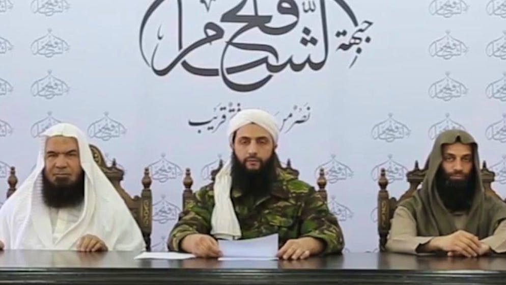 Abu Muhammad al-Dschaulani (Mitte) erklärt 2016 die Auflösung seiner al-Nusra-Front, um dann die 2017 gegründete HTS zu leiten.