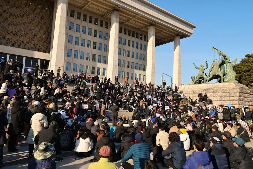 Des personnes se rassemblent devant l'Assemblée nationale à Séoul, Corée du Sud, 04 décembre 2024. Le président sud-coréen Yoon Suk Yeol a annoncé son intention de lever la loi martiale d'urgence quelques heures après que l'Assemblée nationale a voté à l'unanimité en faveur d'une résolution exhortant le président à retirer la loi martiale lors d'une session plénière d'urgence. M. Yoon avait déclaré la loi martiale la nuit précédente, citant la nécessité d'éradiquer les forces pro-nord-coréennes et de maintenir l'ordre constitutionnel.