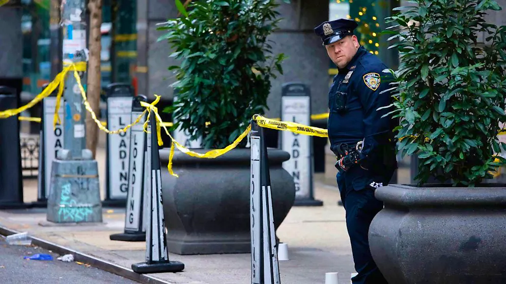 dpatopbilder - A New York police officer stands at a cordoned off area in front of a building entrance near Times Square. Photo: Stefan Jeremiah/AP/dpa