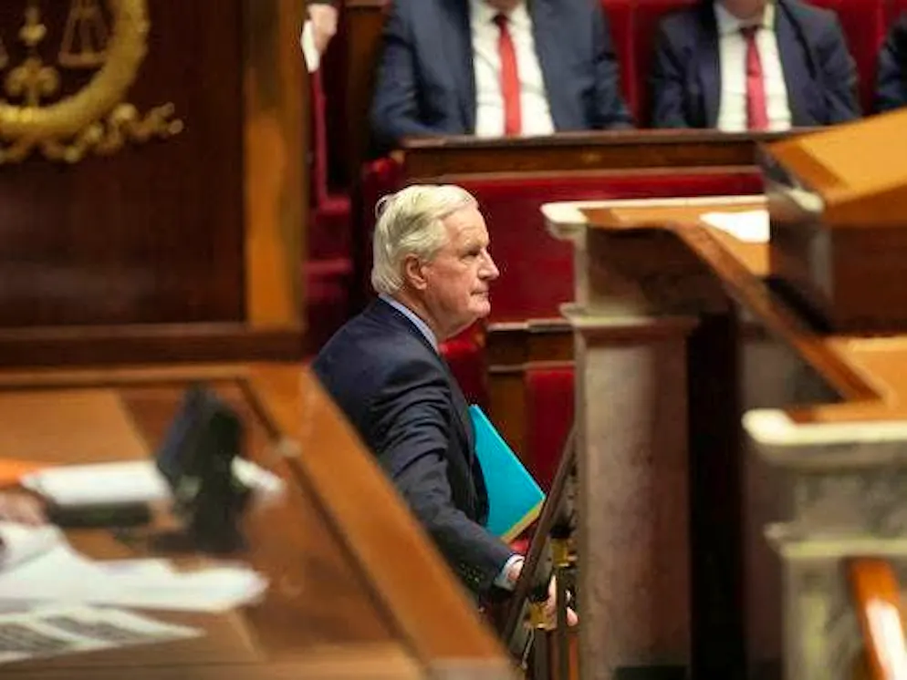 French Prime Minister Michel Barnier leaves the lectern in the National Assembly before the vote on a motion of no confidence.
