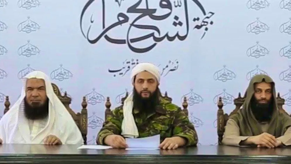 Abu Muhammad al-Jaulani (center) declares the dissolution of his al-Nusra Front in 2016 in order to lead the HTS, which was founded in 2017.