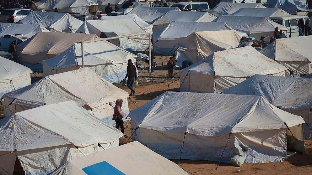 Flüchtlinge gehen zwischen den Zelten in einem Lager in der Stadt Tabqa im Gouvernement Raqqa im Norden Syriens. Foto: Hogir El Abdo/AP/dpa