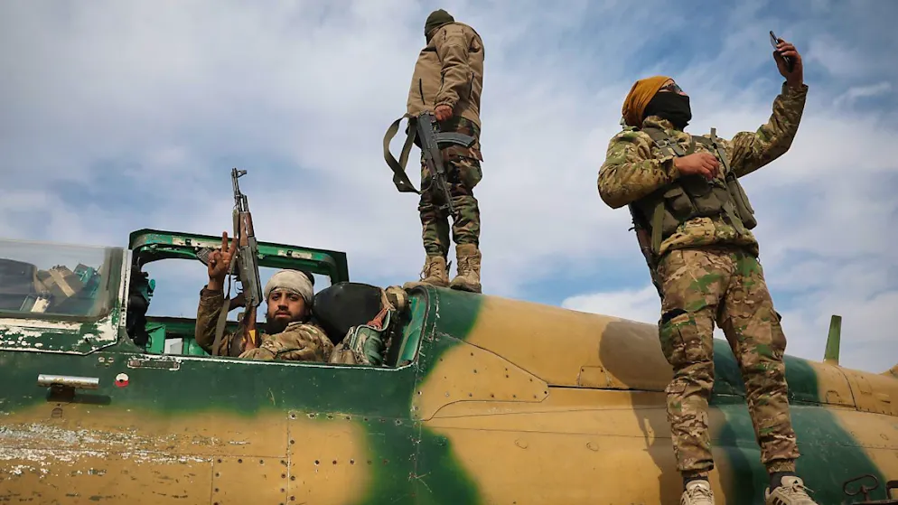 Syrische Oppositionskämpfer stehen auf einem beschlagnahmten Kampfflugzeug der syrischen Luftwaffe auf dem Militärflughafen von Hama.