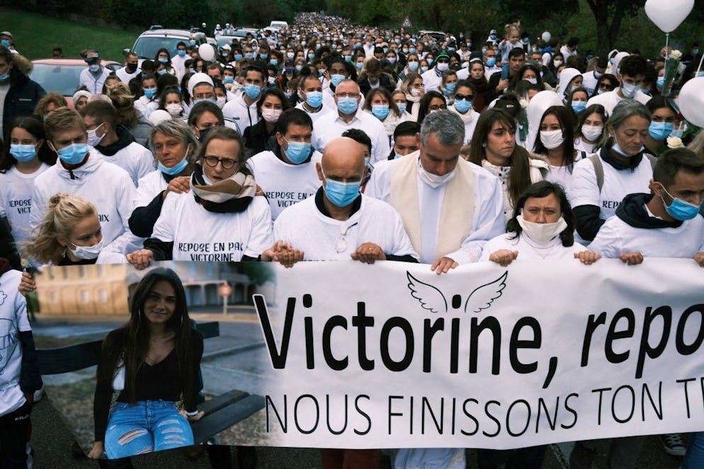 Les parents de Victorine (C) tiennent une banderole alors que des personnes participent à une marche blanche à Villefontaine, dans le sud-est de la France, le 4 octobre 2020. - Le 5 décembre 2024, Ludovic Bertin a été condamné à la réclusion criminelle à perpétuité pour le meurtre et la tentative de viol de Victorine Dartois. 