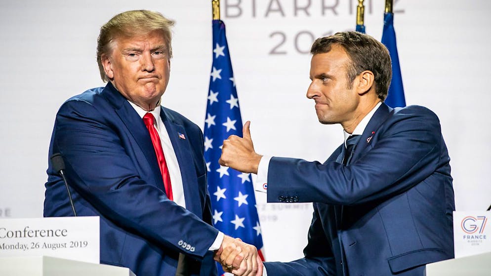 ARCHIV - Emmanuel Macron (r), Präsident von Frankreich, reckt den Daumen, und gibt Donald Trump (l), Präsident der USA, während der Abschluss-Pressekonferenz nach dem G7-Gipfel die Hand. Foto: Michael Kappeler/dpa