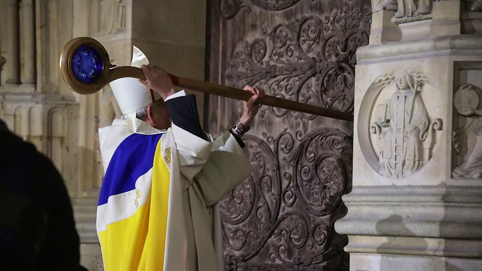 Notre-Dame a rouvert, cinq ans après avoir été sauvée des flammes - Gallery. A 19h20, l'archevêque de Paris Laurent Ulrich, dans une tenue dessinée par le styliste français Jean-Charles de Castelbajac, a symboliquement fait ouvrir les portes sur lesquelles il a donné neuf coups de crosse.