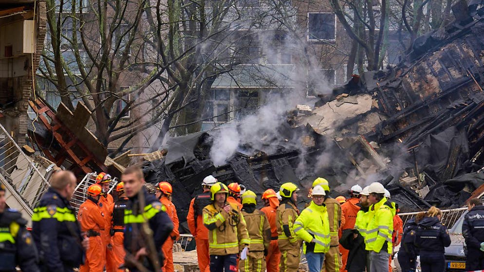 dpatopbilder - Feuerwehrleute stehen vor einem zerstörten Gebäude am Ort einer Explosion, bei der mehrere Wohnungen zerstört und mehrere Menschen verletzt wurden. Foto: Phil Nijhuis/AP/dpa