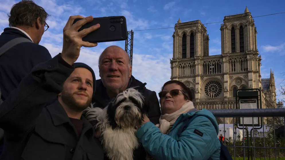 Touristen fotografieren sich am 6. Dezember in Paris vor dem renovierten Wahrzeichen.