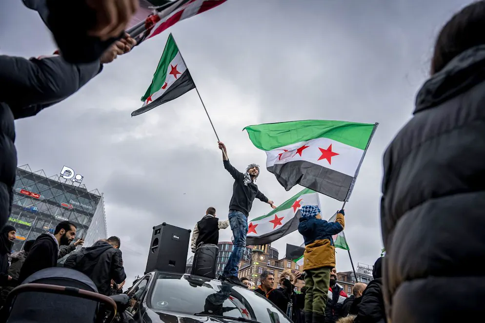 Des personnes et des membres de l'Association syrienne au Danemark portent des drapeaux de l'opposition syrienne alors qu'ils célèbrent la prise de Damas par les rebelles, à Copenhague, au Danemark, le 8 décembre 2024.