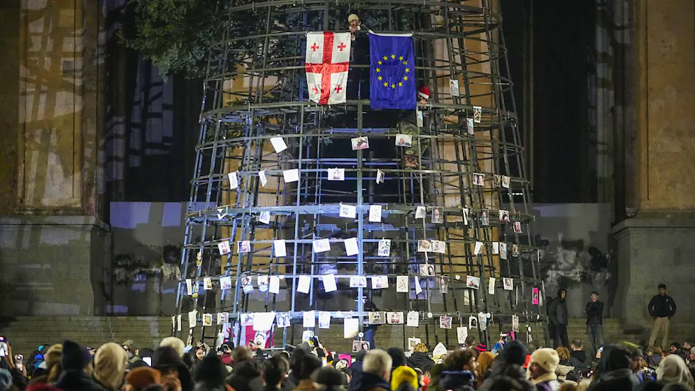 Les manifestants ont accroché des photos des protestaires frappés par la police sur les échafaudages qui soutiennent le sapin de Noël devant le parlement.