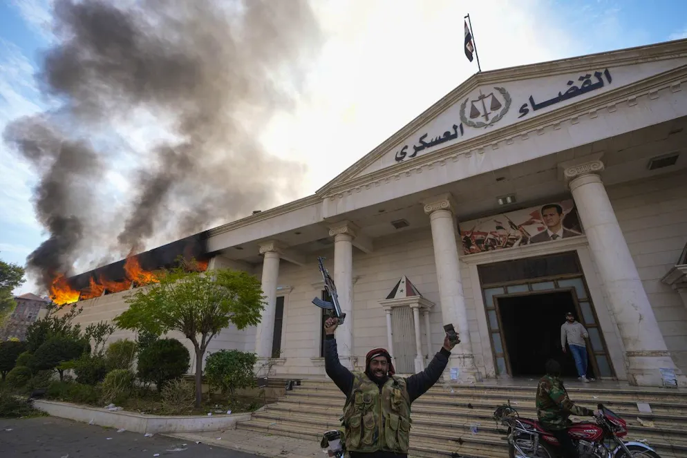 Der Umsturz in Syrien in Bildern. Rebellen posieren vor einem Militärgericht in Damaskus am 8. Dezember. Dieses hatten sie zuvor in Brand gesteckt. Der Machtwechsel in Syrien und auch die Einnahme der Hauptstadt verliefen aber offenbar mehrheitlich ohne grössere Kämpfe. Die Rebellen-Allianz hatte zuvor angekündigt, sämtliches «Eigentum des syrischen Volkes» zu beschützen, und ihre Kämpfer dazu aufgerufen, sich von Regierungseinrichtungen fernzuhalten.