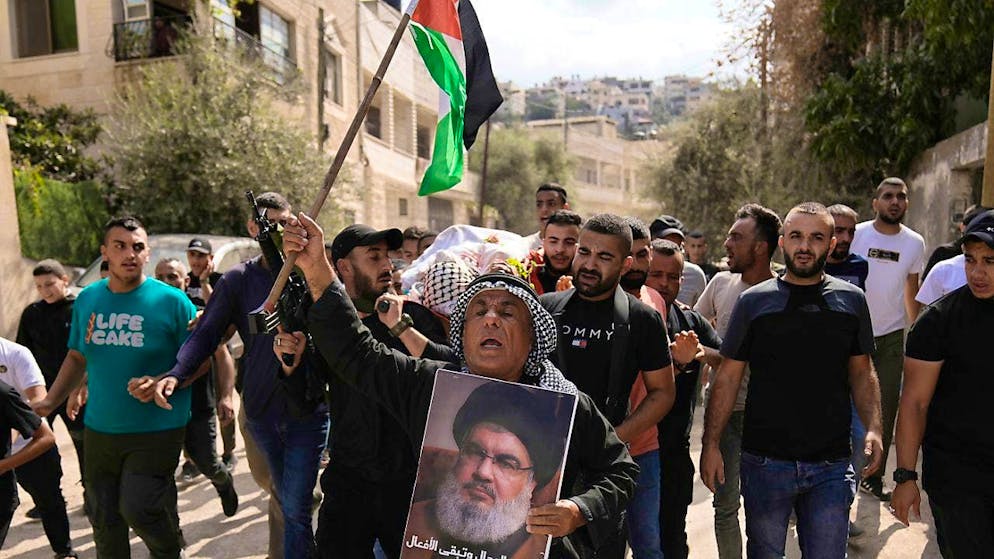 ARCHIVE - Palestinian activist Khairi Hanoun holds a poster in Jenin of slain Hezbollah chief Nasrallah, who was killed in an Israeli attack in September. Photo: Majdi Mohammed/AP/dpa