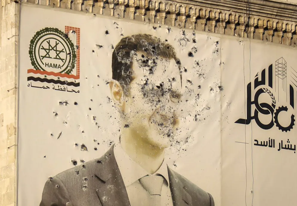 Une image de Bachar al-Assad, criblée de balles, sur la façade du bâtiment de l'administration provinciale après la prise de contrôle de Hamas par l'opposition, en Syrie, le 6 décembre 2024.