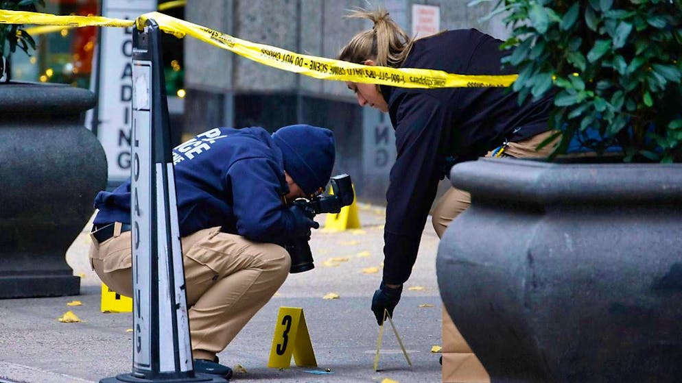 ARCHIVE - Members of the New York Police Department photograph bullets lying on the sidewalk as they investigate a crime scene at the entrance house near Times Square. Photo: Stefan Jeremiah/FR171756 AP/dpa