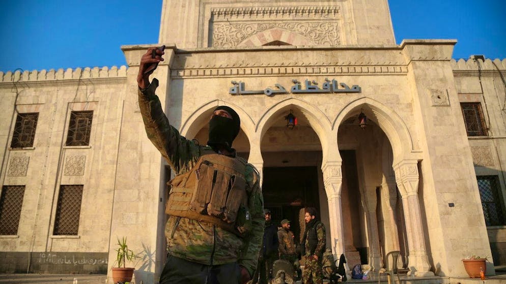 The Islamists are here: a fighter takes a selfie in front of a government building in Hama on the 6th.
