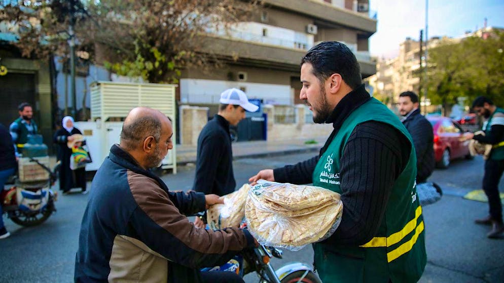 A local humanitarian organization distributes bread to people in the streets of Damascus. Photo: Juma Muhammad/IMAGESLIVE via ZUMA Press Wire/dpa