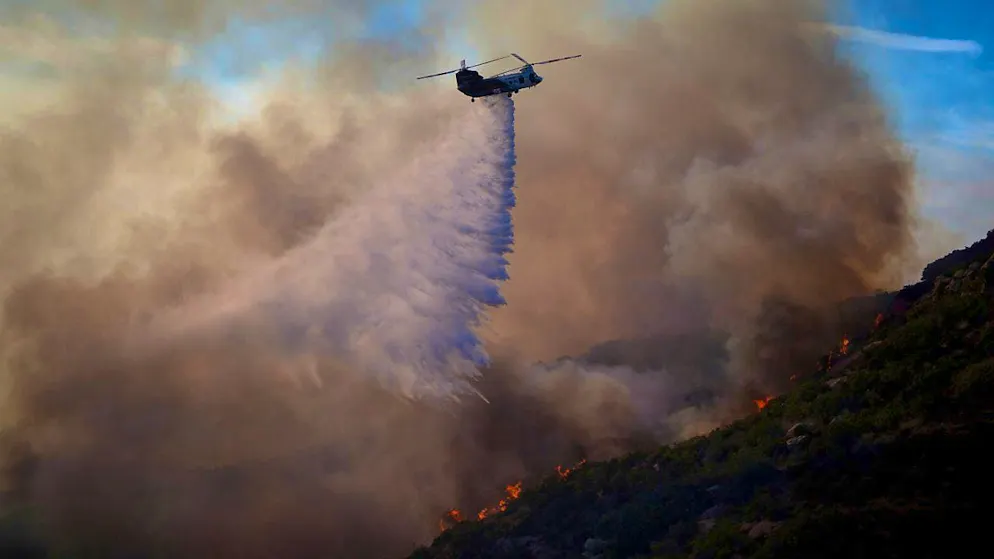 A helicopter drops water on the Franklin Fire in Malibu, USA. Photo: Eric Thayer/AP/dpa