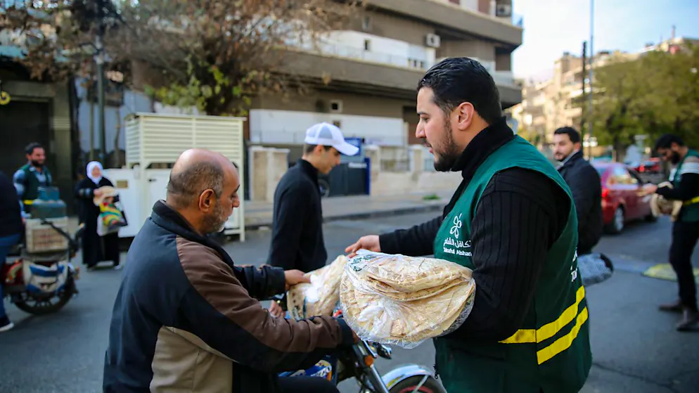 Eine örtliche humanitäre Organisation verteilt Brot an Menschen in den Straßen von Damaskus. Foto: Juma Muhammad/IMAGESLIVE via ZUMA Press Wire/dpa