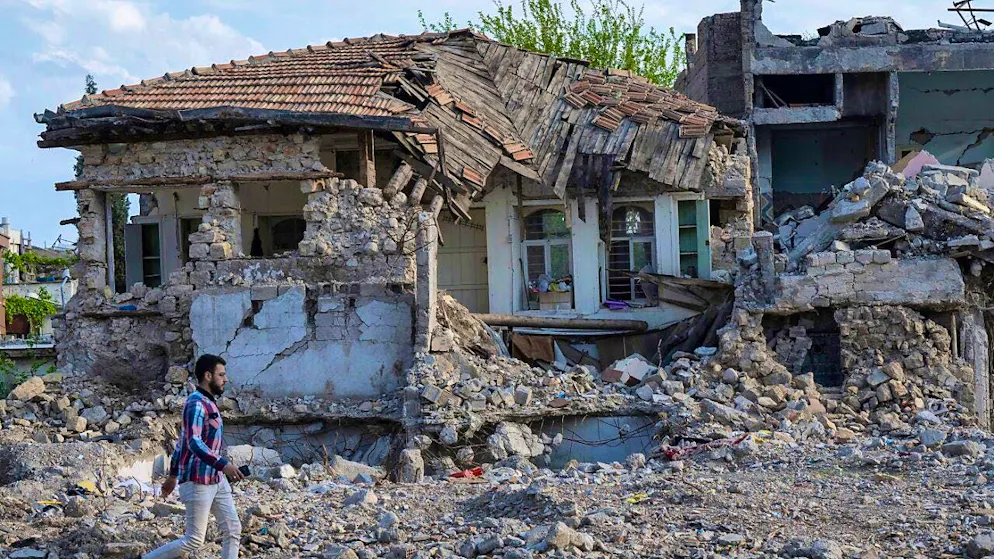 ARCHIVE - A man walks past the rubble of collapsed houses in the old town of Kahramanmaras. Photo: Boris Roessler/dpa