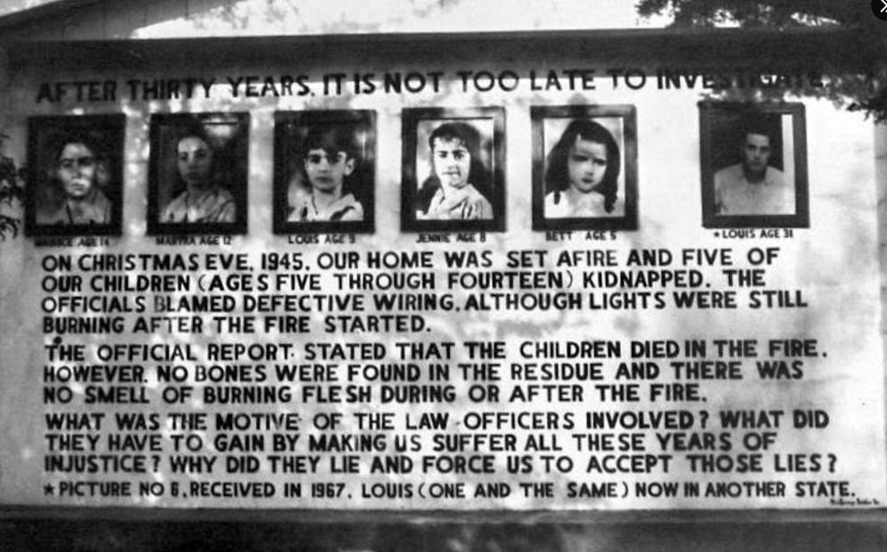 Wo früher das Haus stand, stehen heute Tafeln mit Bildern der vermissten Kinder.