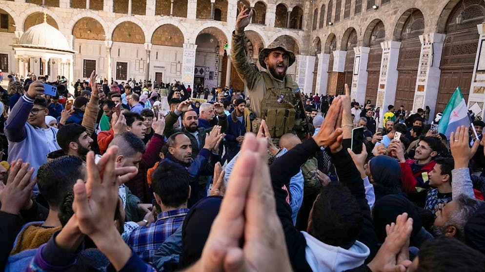 Syrische Kämpfer und Zivilisten skandieren Slogans, während sie sich vor dem Freitagsgebet in der Umayyad-Moschee in Damaskus versammeln. Foto: Leo Correa/AP/dpa