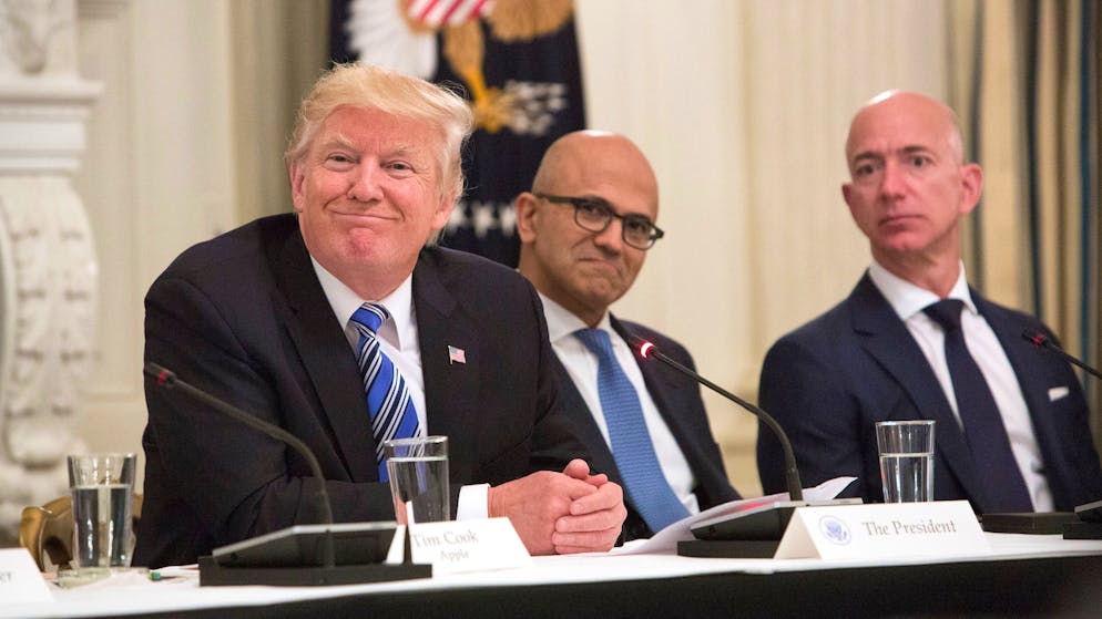 Der damalige und künftige US-Präsident Donald Trump (l.) mit Microsoft-CEO Satya Nadella (M.) und Amazon-Gründer Jeff Bezos (r.) bei einem Roundtable mit den Chefs der Technologiebranche im Juni 2017. 