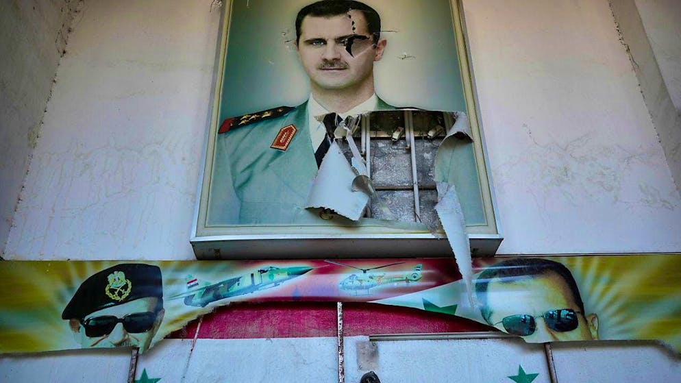 dpatopbilder - A torn poster shows ousted Syrian President Bashar al-Assad at the entrance to a prison in Damascus. Photo: Hussein Malla/AP/dpa