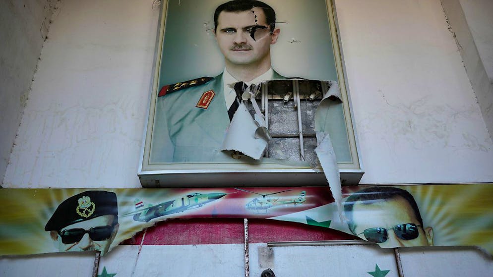 dpatopbilder - Ein zerrissenes Plakat zeigt den gestürzten syrischen Präsidenten Baschar al-Assad am Eingang eines Gefängnisses in Damaskus. Foto: Hussein Malla/AP/dpa