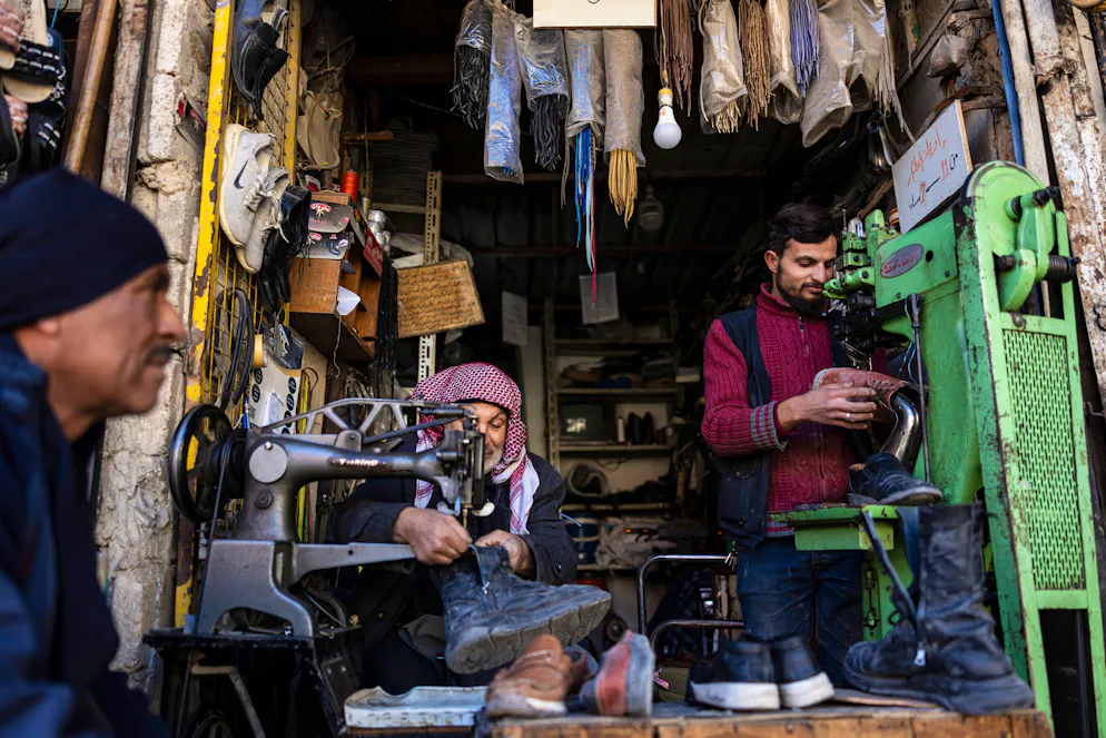 Des cordonniers travaillent dans leur atelier dans la ville de Douma, à la périphérie de la capitale syrienne Damas, le 15 décembre 2024.