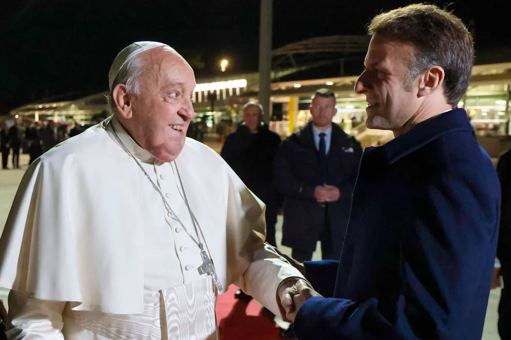 Le pape François (à gauche) serre la main du président français Emmanuel Macron (à droite) lors de la cérémonie de départ du pape à l'aéroport d'Ajaccio, sur l'île française de Corse, le 15 décembre 2024.