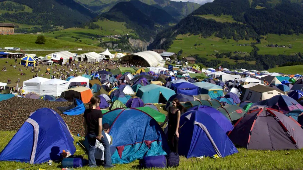Besucher des 18. Open Air Val Lumnezia im Jahr 2002 suchen sich einen Platz aus in der Zeltstadt. Bei herrlichem Sommerwetter war damals das grösste Bündner Open Air mit 8900 Besuchern erstmals ausverkauft. (KEYSTONE/Juergen Staiger).