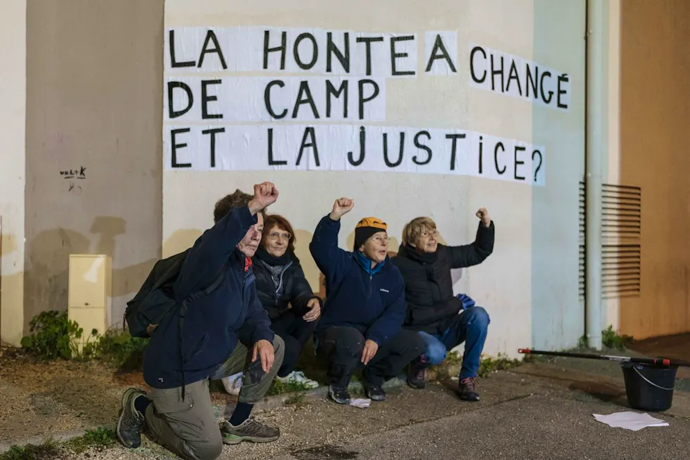 Des membres du collectif féministe « Les Amazones Avignon » se tiennent à côté d'un message de soutien à Gisele Pelicot où l'on peut lire « La honte a changé de camp, et la justice ? » lors de leur action de collage de messages autour du palais de justice où se déroule le procès du viol de Mazan à Avignon, France, mercredi 18 décembre 2024. (AP Photo/Lewis Joly)