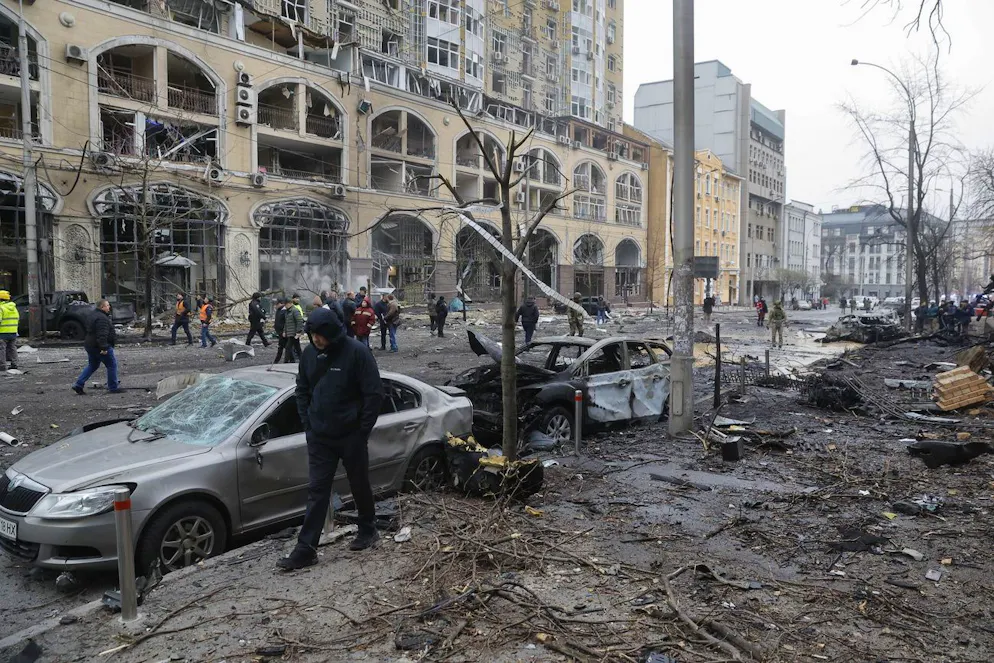 Soccorritori, esperti e agenti di polizia ispezionano i danni sul luogo di un attacco missilistico nel centro di Kiev, in Ucraina, il 20 dicembre 2024.
