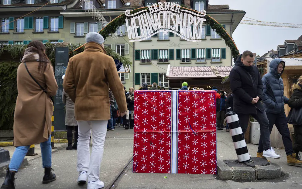 Eine als Geschenk verkleidete Betonsperre vor einem Eingang zum Berner Weihnachtsmarkt auf dem Waisenhausplatz.