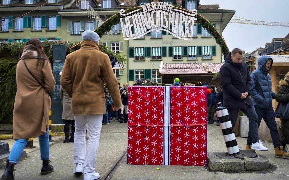 A concrete barrier disguised as a gift in front of an entrance to Bern's Christmas market on Waisenhausplatz.