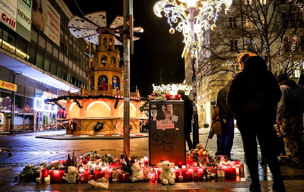 Blumen und Kerzen neben dem Weihnachtsmarkt in Magdeburg, Deutschland.